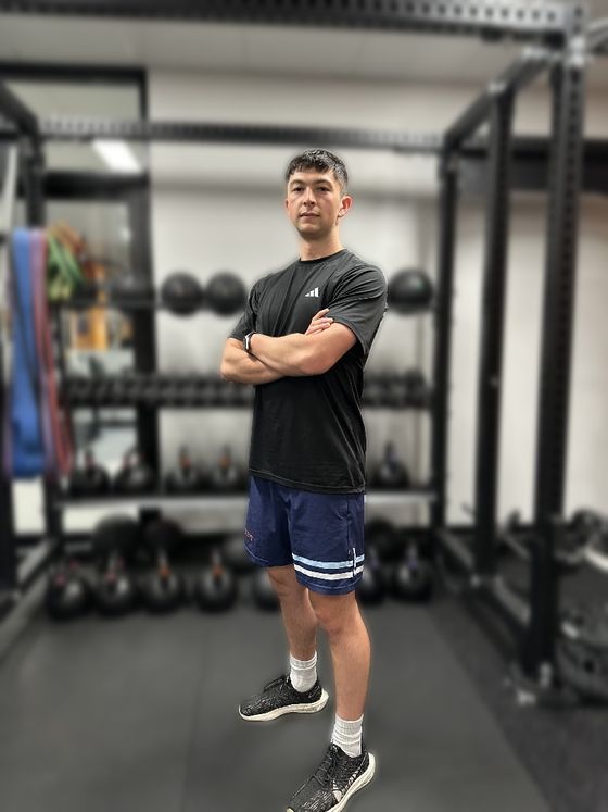 Coach Calyn, personal trainer, standing with arms crossed in a Canberra gym